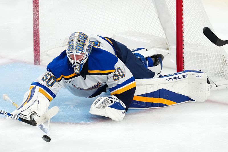 Oct 11, 2024; Las Vegas, Nevada, USA; St. Louis Blues goaltender Jordan Binnington (50) tips the puck away from his net after making a save against the Vegas Golden Knights during the third period at T-Mobile Arena. Mandatory Credit: Stephen R. Sylvanie-Imagn Images