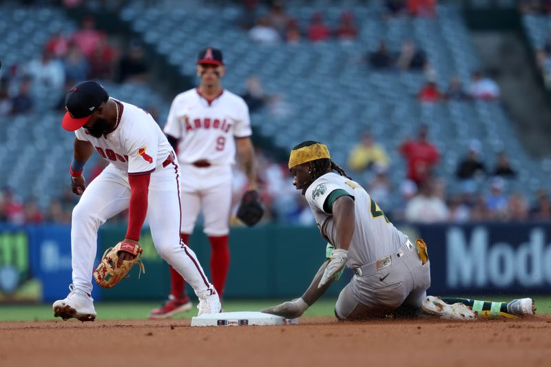 Jul 25, 2024; Anaheim, California, USA;  Oakland Athletics right fielder Lawrence Butler (4) is safe at second base on double ahead of a tag from Los Angeles Angels second baseman Luis Rengifo (2) during the first inning at Angel Stadium. Mandatory Credit: Kiyoshi Mio-USA TODAY Sports