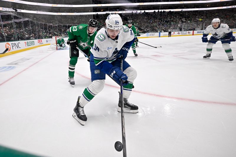 Jan 31, 2025; Dallas, Texas, USA; Dallas Stars defenseman Esa Lindell (23) and Vancouver Canucks center Linus Karlsson (94) chase the puck in the Stars zone during the third period at the American Airlines Center. Mandatory Credit: Jerome Miron-Imagn Images