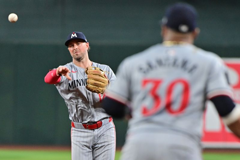 Jun 27, 2024; Phoenix, Arizona, USA;  Minnesota Twins second base Kyle Farmer (12) throws to first baseman Carlos Santana (30) in the third inning against the Arizona Diamondbacks at Chase Field. Mandatory Credit: Matt Kartozian-USA TODAY Sports