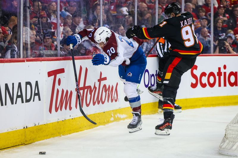 Mar 12, 2024; Calgary, Alberta, CAN; Colorado Avalanche center Ross Colton (20) and Calgary Flames center Nazem Kadri (91) battles for the puck during the first period at Scotiabank Saddledome. Mandatory Credit: Sergei Belski-USA TODAY Sports