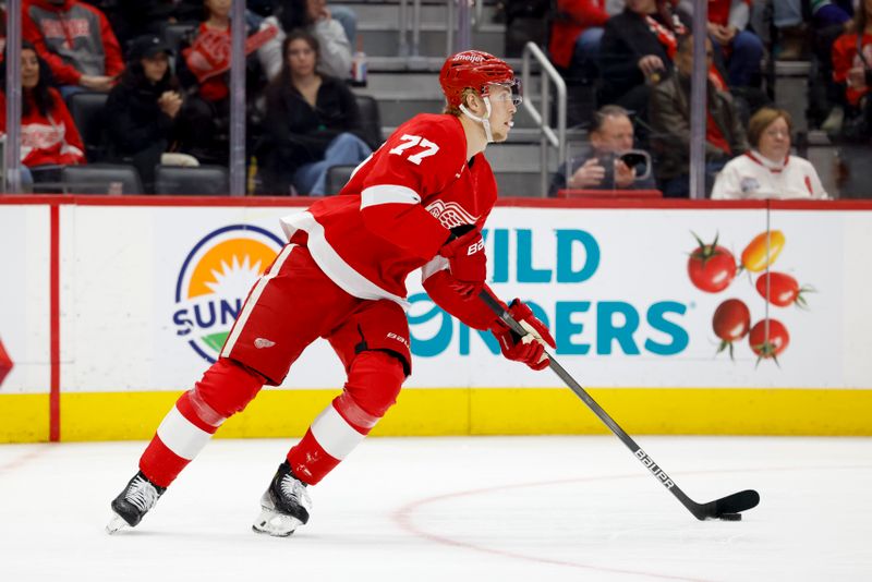 Dec 1, 2024; Detroit, Michigan, USA;  Detroit Red Wings defenseman Simon Edvinsson (77) skates with the puck in the first period against the Vancouver Canucks at Little Caesars Arena. Mandatory Credit: Rick Osentoski-Imagn Images