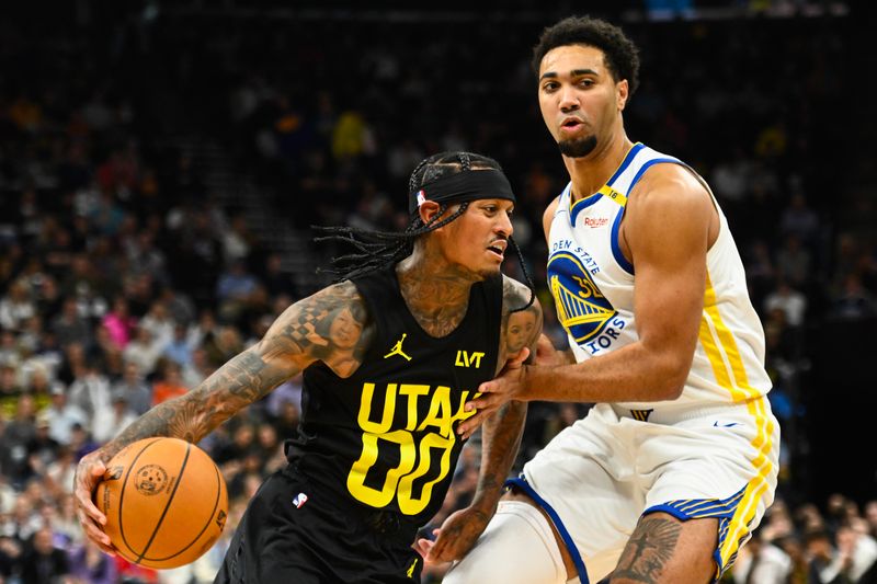 SALT LAKE CITY, UTAH - OCTOBER 25: Jordan Clarkson #00 of the Utah Jazz drives into Trayce Jackson-Davis #32 of the Golden State Warriors during the first half of a game at Delta Center on October 25, 2024 in Salt Lake City, Utah. NOTE TO USER: User expressly acknowledges and agrees that, by downloading and or using this photograph, User is consenting to the terms and conditions of the Getty Images License Agreement. (Photo by Alex Goodlett/Getty Images)