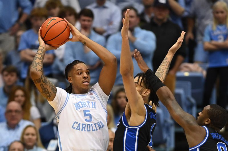 Mar 4, 2023; Chapel Hill, North Carolina, USA;  North Carolina Tar Heels forward Armando Bacot (5) looks to pass as Duke Blue Devils center Dereck Lively II (1) defends in the first half at Dean E. Smith Center. Mandatory Credit: Bob Donnan-USA TODAY Sports