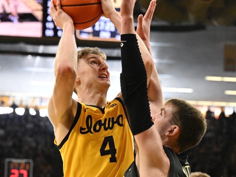 Jan 20, 2024; Iowa City, Iowa, USA; Iowa Hawkeyes guard Josh Dix (4) goes to the basket as Purdue Boilermakers guard Braden Smith (3) defends during the second half at Carver-Hawkeye Arena. Mandatory Credit: Jeffrey Becker-USA TODAY Sports