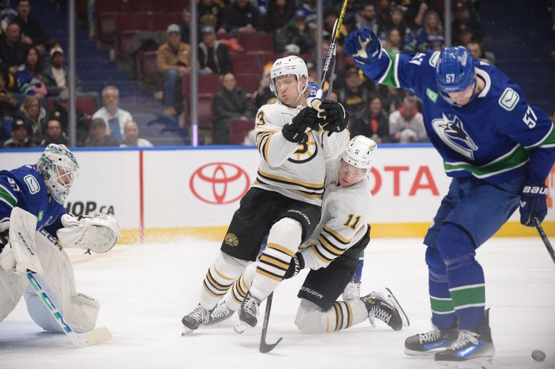 Feb 24, 2024; Vancouver, British Columbia, CAN;  Boston Bruins forward Charlie Coyle (13) collides with forward Trent Frederic (11) in front of the net of Vancouver Canucks goaltender Thatcher Demko (35) during the second period at Rogers Arena. Mandatory Credit: Anne-Marie Sorvin-USA TODAY Sports