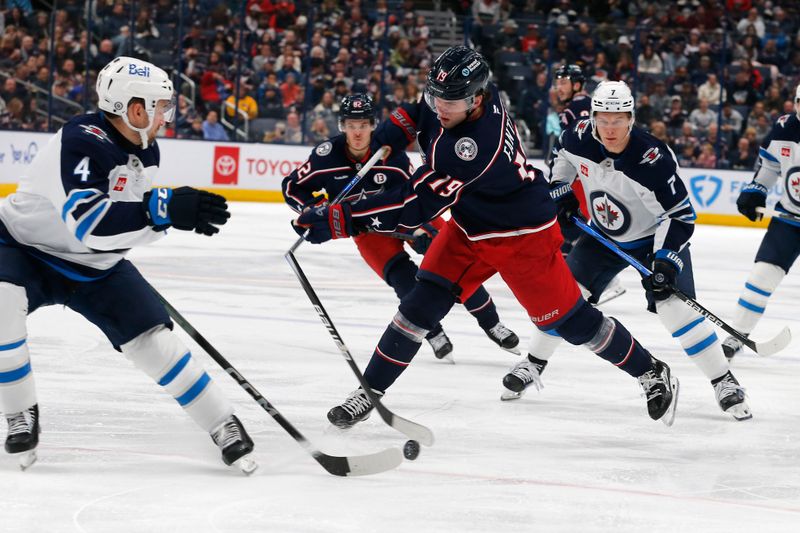 Nov 1, 2024; Columbus, Ohio, USA; Columbus Blue Jackets center Adam Fantilli (19) breaks a stick on a slap shot as Winnipeg Jets defenseman Neal Pionk (4)] defends during the second period at Nationwide Arena. Mandatory Credit: Russell LaBounty-Imagn Images