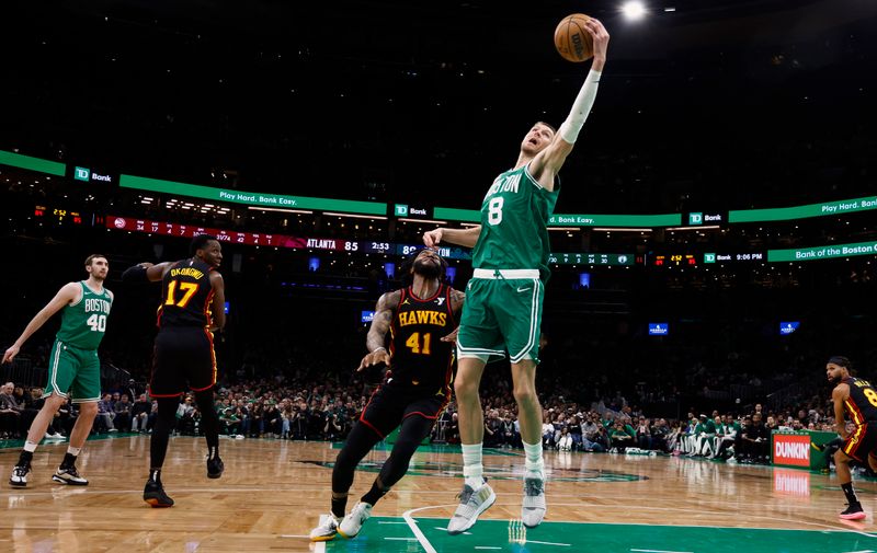 BOSTON, MA - FEBRUARY 7: Kristaps Porzingis #8 of the Boston Celtics receives a pass behind Saddiq Bey #41 of the Atlanta Hawks during the second half at TD Garden on February 7, 2024 in Boston, Massachusetts. NOTE TO USER: User expressly acknowledges and agrees that, by downloading and/or using this Photograph, user is consenting to the terms and conditions of the Getty Images License Agreement. (Photo By Winslow Townson/Getty Images)