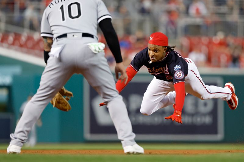 Sep 19, 2023; Washington, District of Columbia, USA; Washington Nationals shortstop CJ Abrams (5) dives into third base with a triple ahead of a tag by Chicago White Sox third baseman Yoan Moncada (10) during the first inning at Nationals Park. Mandatory Credit: Geoff Burke-USA TODAY Sports