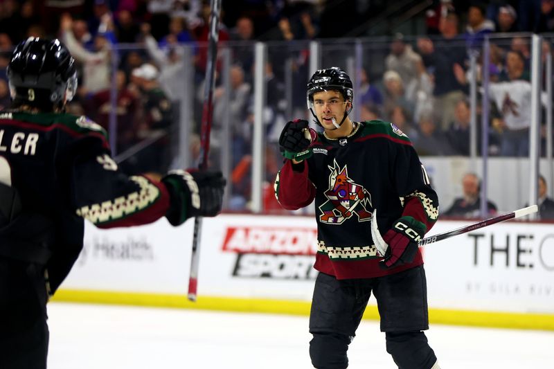 Feb 21, 2024; Tempe, Arizona, USA; Arizona Coyotes right wing Dylan Guenther (11) celebrates with Arizona Coyotes right wing Clayton Keller (9) after scoring a goal during the second period against the Toronto Maple Leafs at Mullett Arena. Mandatory Credit: Mark J. Rebilas-USA TODAY Sports