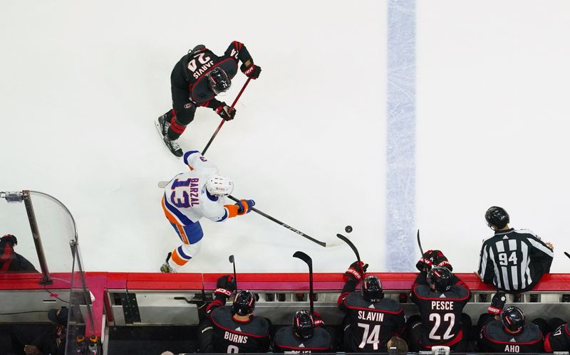 Apr 22, 2024; Raleigh, North Carolina, USA; New York Islanders center Mathew Barzal (13) skates with the puck against Carolina Hurricanes center Seth Jarvis (24) during the second period in game two of the first round of the 2024 Stanley Cup Playoffs at PNC Arena. Mandatory Credit: James Guillory-USA TODAY Sports