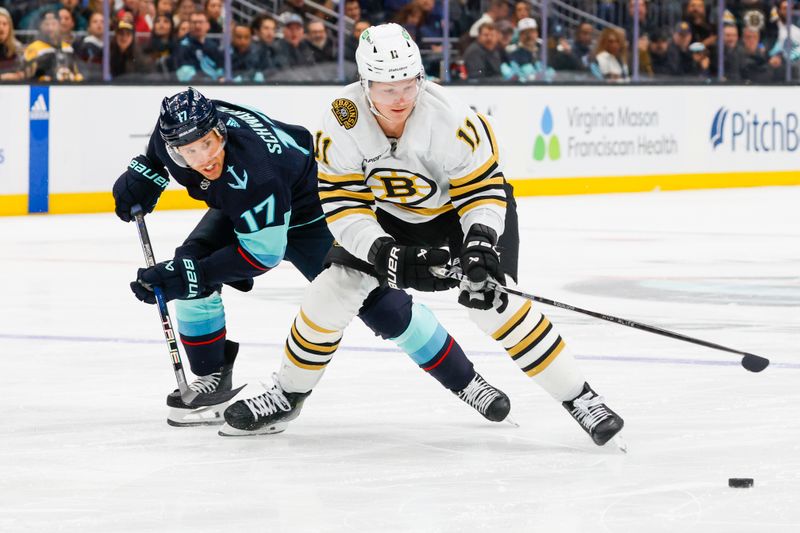 Feb 26, 2024; Seattle, Washington, USA; Boston Bruins center Trent Frederic (11) takes control of the puck ahead of Seattle Kraken center Jaden Schwartz (17) during the second period at Climate Pledge Arena. Mandatory Credit: Joe Nicholson-USA TODAY Sports