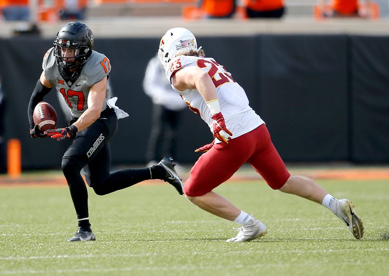 Oct 24, 2020; Stillwater, Oklahoma, USA;  Oklahoma State Cowboys wide receiver Dillon Stoner (17) catches a pass as Iowa State Cyclones linebacker Mike Rose (23) defends in the first quarter at Boone Pickens Stadium. Mandatory Credit: Sarah Phipps-USA TODAY Sports
