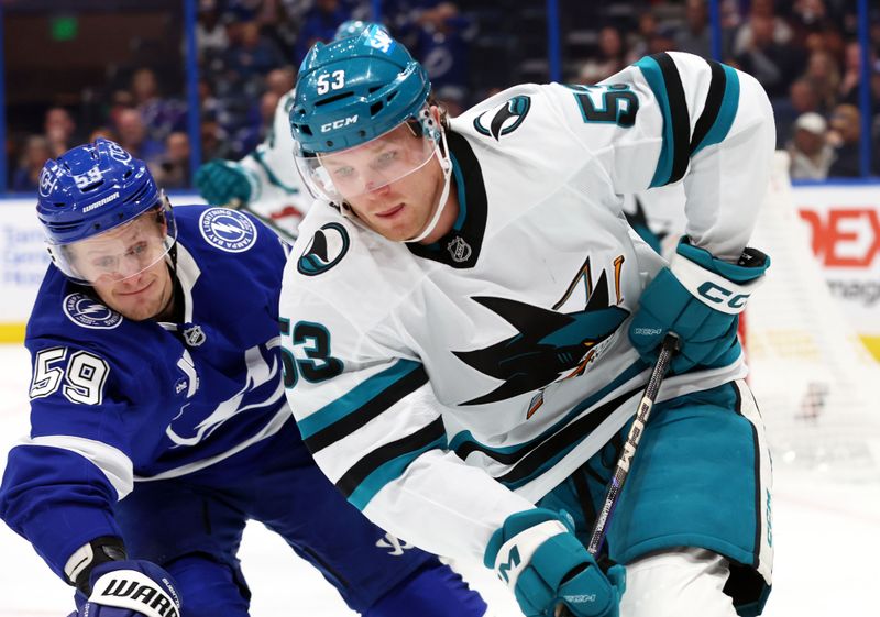 Dec 5, 2024; Tampa, Florida, USA; San Jose Sharks center Ty Dellandrea (53) skates as Tampa Bay Lightning center Jake Guentzel (59) defends during the first period at Amalie Arena. Mandatory Credit: Kim Klement Neitzel-Imagn Images