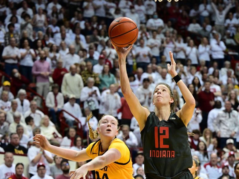 Feb 22, 2024; Bloomington, Indiana, USA; Indiana Hoosiers guard Yarden Garzon (12) shoots the ball after getting past Iowa Hawkeyes forward Addison O'Grady (44) during the second half at Simon Skjodt Assembly Hall. Mandatory Credit: Marc Lebryk-USA TODAY Sports