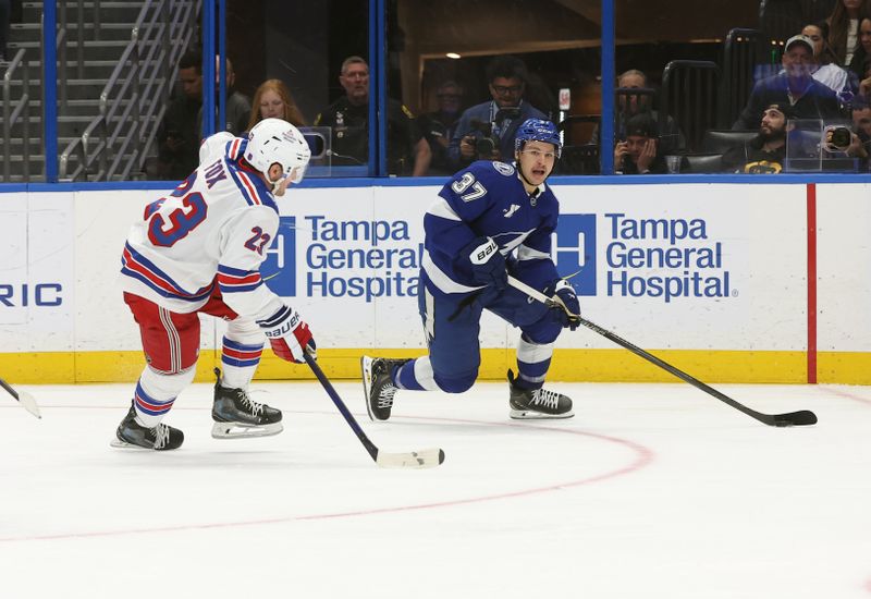 Nov 12, 2025; Tampa, Florida, USA;  Tampa Bay Lightning center Yanni Gourde (37) skates with the puck as New York Rangers defenseman Adam Fox (23) defends during the third period at Benchmark International Arena. Mandatory Credit: Kim Klement Neitzel-Imagn Images