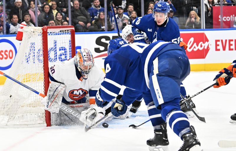 Feb 5, 2024; Toronto, Ontario, CAN;   New York Islanders goalie Ilya Sorokin (30) makes a save on a shot from Toronto Maple Leafs defenseman Morgan Rielly (44) as forward Tyler Bertuzzi (59) looks for a rebound in the third  period at Scotiabank Arena. Mandatory Credit: Dan Hamilton-USA TODAY Sports