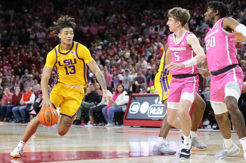 Jan 24, 2023; Fayetteville, Arkansas, USA; LSU Tigers forward Jalen Reed (13) dribbles into the lane as Arkansas Razorbacks guard Joseph Pinion (5) and forward Kamani Johnson (20) defend at Bud Walton Arena. Arkansas won 60-40. Mandatory Credit: Nelson Chenault-USA TODAY Sports