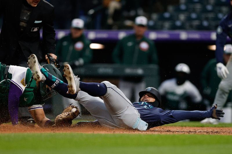 Apr 20, 2024; Denver, Colorado, USA; Seattle Mariners left fielder Jonatan Clase (5) is tagged out at home by Colorado Rockies catcher Elias Diaz (35) attempting to stretch a single on a Rockies fielding error in the fifth inning at Coors Field. Mandatory Credit: Isaiah J. Downing-USA TODAY Sports