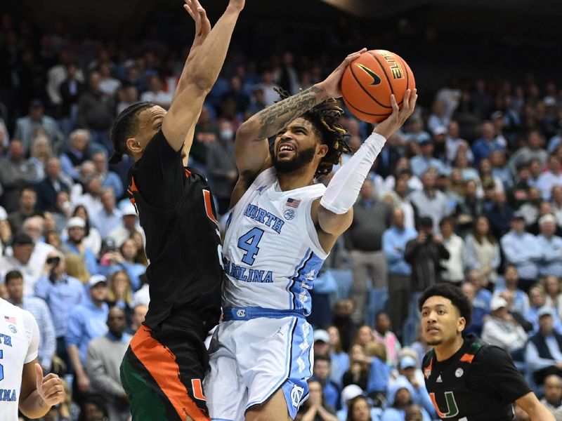 Feb 13, 2023; Chapel Hill, North Carolina, USA; North Carolina Tar Heels guard R.J. Davis (4) shoots as Miami (Fl) Hurricanes guard Isaiah Wong (2) defends in the second half at Dean E. Smith Center. Mandatory Credit: Bob Donnan-USA TODAY Sports