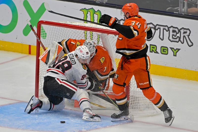 Nov 3, 2024; Anaheim, California, USA;  Chicago Blackhawks center Connor Bedard (98) crashes into Anaheim Ducks goaltender Lukas Dostal (1) as Anaheim Ducks defenseman Pavel Mintyukov (34) assists in the second period at Honda Center. Mandatory Credit: Jayne Kamin-Oncea-Imagn Images