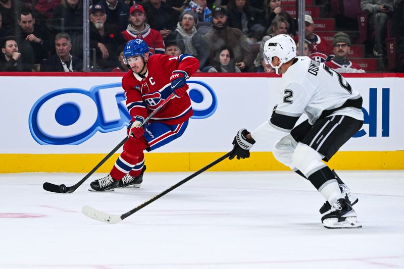 Nov 11, 2025; Montreal, Quebec, CAN; Montreal Canadiens center Nick Suzuki (14) plays the puck against Los Angeles Kings defenseman Brian Dumoulin (2) during the third period at Bell Centre. Mandatory Credit: David Kirouac-Imagn Images