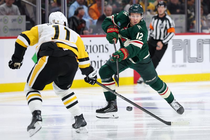 Oct 30, 2025; Saint Paul, Minnesota, USA; Minnesota Wild left wing Matt Boldy (12) shoots as Pittsburgh Penguins center Filip Hallander (11) defends during the second period at Grand Casino Arena. Mandatory Credit: Matt Krohn-Imagn Images