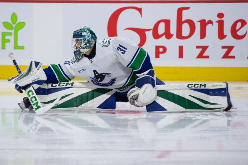 Nov 23, 2024; Ottawa, Ontario, CAN; Vancouver Canucks goalie Arturs Silovs (31) stretches during warmup prior to game against the Ottawa Senators at the Canadian Tire Centre. Mandatory Credit: Marc DesRosiers-Imagn Images