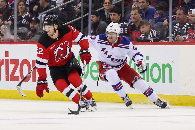 Apr 5, 2025; Newark, New Jersey, USA; New Jersey Devils defenseman Brett Pesce (22) skates with the puck as New York Rangers left wing Alexis Lafrenière (13) defends during the third period at Prudential Center. Mandatory Credit: Ed Mulholland-Imagn Images
