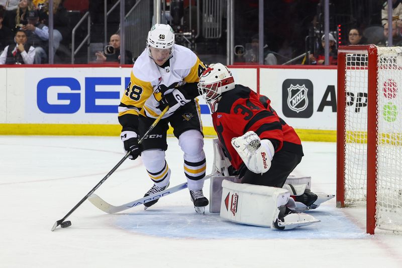 Mar 19, 2024; Newark, New Jersey, USA; Pittsburgh Penguins right wing Valtteri Puustinen (48) plays the puck in front of New Jersey Devils goaltender Jake Allen (34) during the first period at Prudential Center. Mandatory Credit: Ed Mulholland-USA TODAY Sports