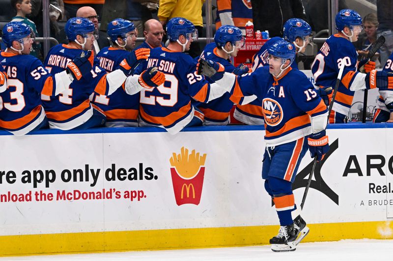 Mar 23, 2024; Elmont, New York, USA;  New York Islanders right wing Cal Clutterbuck (15) celebrates his first goal during the first period  against the Winnipeg Jets at UBS Arena. Mandatory Credit: Dennis Schneidler-USA TODAY Sports