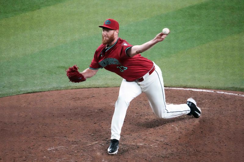 Jul 28, 2024; Phoenix, Arizona, USA; Arizona Diamondbacks pitcher A.J. Puk (33) pitches against the Pittsburgh Pirates during the seventh inning at Chase Field. Mandatory Credit: Joe Camporeale-USA TODAY Sports