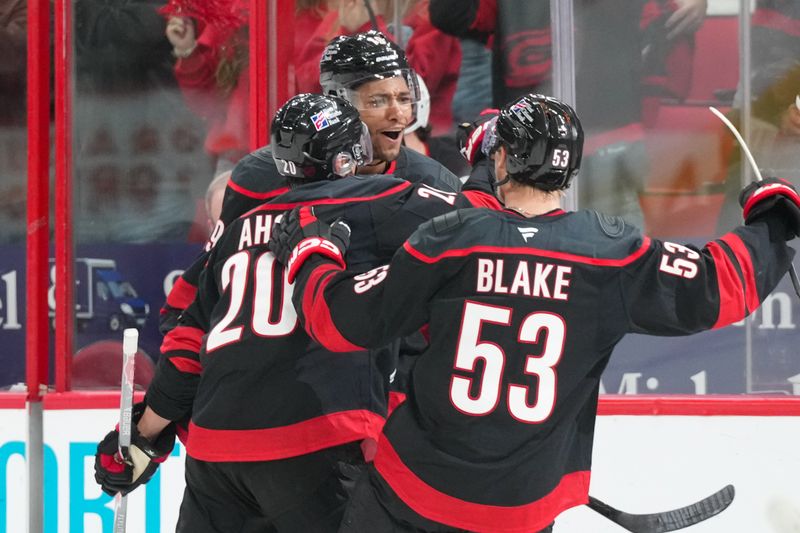 Oct 9, 2025; Raleigh, North Carolina, USA;  Carolina Hurricanes defenseman K'Andre Miller (19) celebrates his goal with center Sebastian Aho (20) and right wing Jackson Blake (53) against the New Jersey Devils during the third period at Lenovo Center. Mandatory Credit: James Guillory-Imagn Images