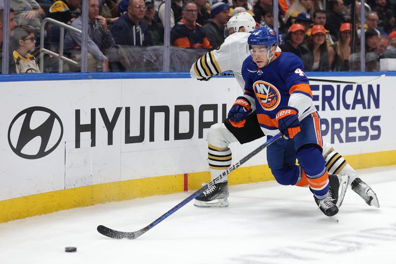 Mar 2, 2024; Elmont, New York, USA; New York Islanders center Jean-Gabriel Pageau (44) fights for the puck against Boston Bruins center Charlie Coyle (13) during the first period at UBS Arena. Mandatory Credit: Brad Penner-USA TODAY Sports