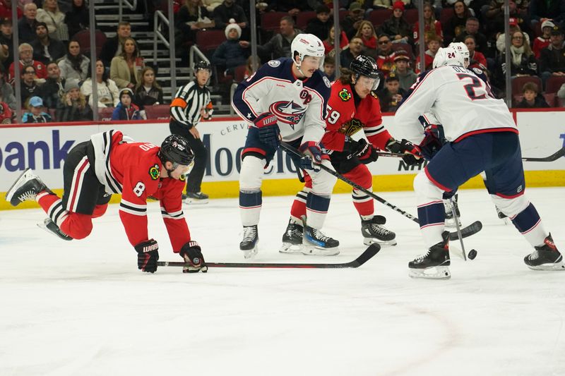 Dec 1, 2024; Chicago, Illinois, USA; Columbus Blue Jackets right wing Mathieu Olivier (24) and Chicago Blackhawks center Ryan Donato (8) go for the puck during the first period at United Center. Mandatory Credit: David Banks-Imagn Images