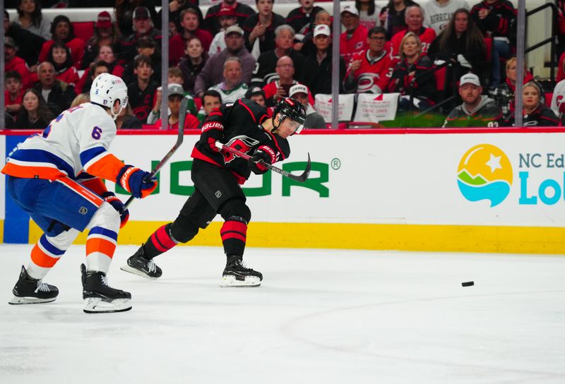 Apr 22, 2024; Raleigh, North Carolina, USA; Carolina Hurricanes center Jack Drury (18) shoots against New York Islanders defenseman Ryan Pulock (6) during the first period in game two of the first round of the 2024 Stanley Cup Playoffs at PNC Arena. Mandatory Credit: James Guillory-USA TODAY Sports