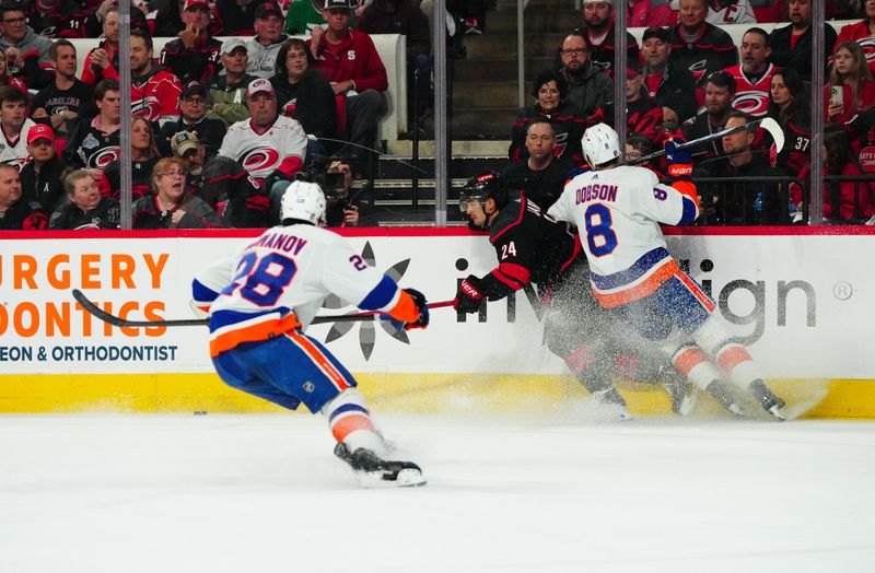 Apr 22, 2024; Raleigh, North Carolina, USA; New York Islanders defenseman Noah Dobson (8) checks Carolina Hurricanes center Seth Jarvis (24) during the first period  in game two of the first round of the 2024 Stanley Cup Playoffs at PNC Arena. Mandatory Credit: James Guillory-USA TODAY Sports