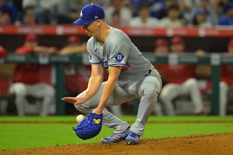 Sep 3, 2024; Anaheim, California, USA;  Los Angeles Dodgers starting pitcher Walker Buehler (21) is able to control the ball and throw Los Angeles Angels first baseman Nolan Schanuel (18) out at first in the fifth inning at Angel Stadium. Mandatory Credit: Jayne Kamin-Oncea-Imagn Images