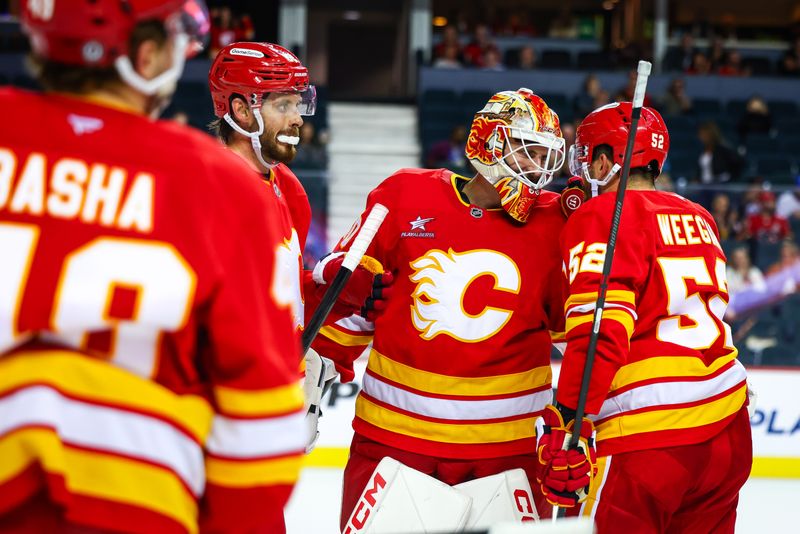 Sep 23, 2024; Calgary, Alberta, CAN; Calgary Flames goaltender Waltteri Ignatjew (40) celebrate win with teammates after defeating Edmonton Oilers at Scotiabank Saddledome. Mandatory Credit: Sergei Belski-Imagn Images