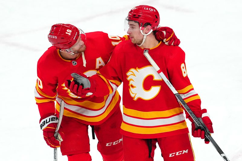 Jan 13, 2024; Las Vegas, Nevada, USA; Calgary Flames left wing Andrew Mangiapane (88) talks with Calgary Flames center Jonathan Huberdeau (10) after the Flames defeated the Vegas Golden Knights 3-1 at T-Mobile Arena. Mandatory Credit: Stephen R. Sylvanie-USA TODAY Sports