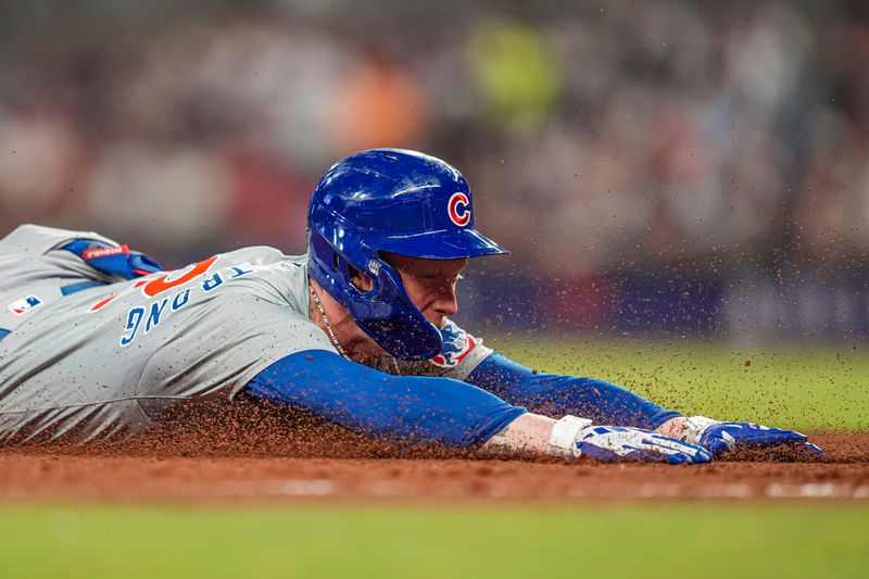 May 15, 2024; Cumberland, Georgia, USA; Chicago Cubs center fielder Pete Crow-Armstrong (52) slides after hitting a triple against the Atlanta Braves during the eight inning at Truist Park. Mandatory Credit: Dale Zanine-USA TODAY Sports