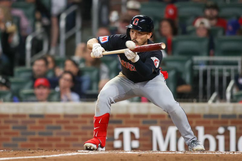 Apr 27, 2024; Atlanta, Georgia, USA; Cleveland Guardians left fielder Steven Kwan (38) singles on a bunt against the Atlanta Braves in the eighth inning at Truist Park. Mandatory Credit: Brett Davis-USA TODAY Sports