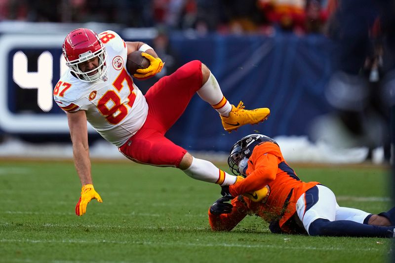 Kansas City Chiefs tight end Travis Kelce (87) is stopped by Denver Broncos safety P.J. Locke during the second half of an NFL football game Sunday, Oct. 29, 2023, in Denver. (AP Photo/Jack Dempsey)