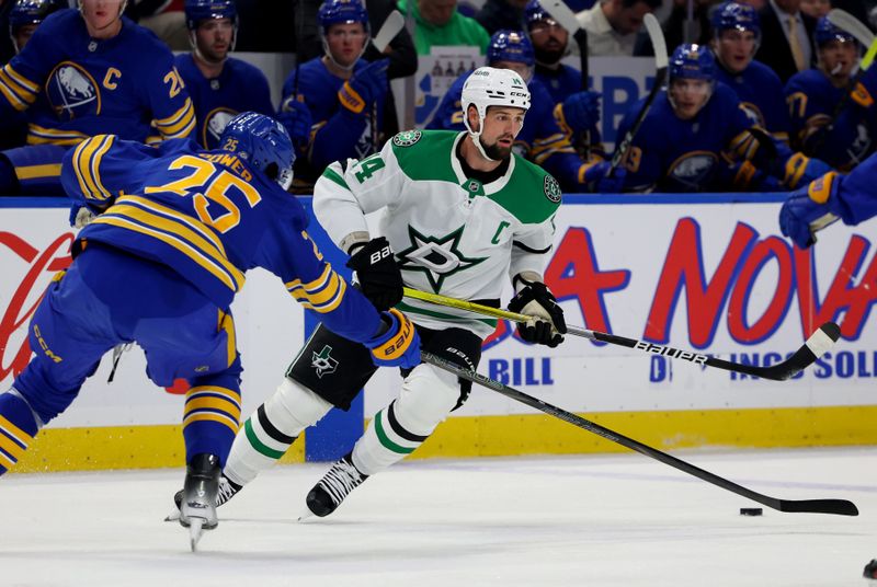 Oct 22, 2024; Buffalo, New York, USA;  Dallas Stars left wing Jamie Benn (14) looks to control the puck as Buffalo Sabres defenseman Owen Power (25) defends during the first period at KeyBank Center. Mandatory Credit: Timothy T. Ludwig-Imagn Images