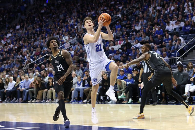 Feb 13, 2024; Provo, Utah, USA; Brigham Young Cougars guard Trevin Knell (21) goes between Central Florida Knights guard Jaylin Sellers (24) and forward C.J. Walker (21) during the second half at Marriott Center. Mandatory Credit: Rob Gray-USA TODAY Sports