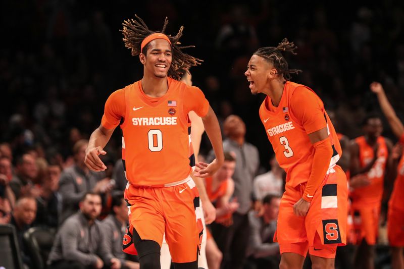 Nov 21, 2022; Brooklyn, New York, USA;  Syracuse Orange forward Chris Bell (0) and guard Judah Mintz (3) celebrate during the overtime against the Richmond Spiders at Barclays Center. Mandatory Credit: Wendell Cruz-USA TODAY Sports