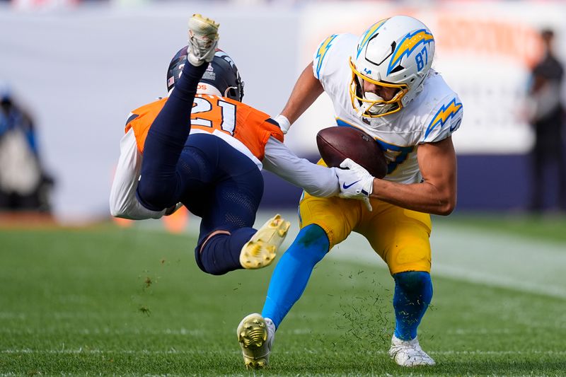 Los Angeles Chargers wide receiver Simi Fehoko (87) catches a pass as Denver Broncos cornerback Riley Moss (21) tries to tackle during the second half of an NFL football game, Sunday, Oct. 13, 2024, in Denver. (AP Photo/David Zalubowski)