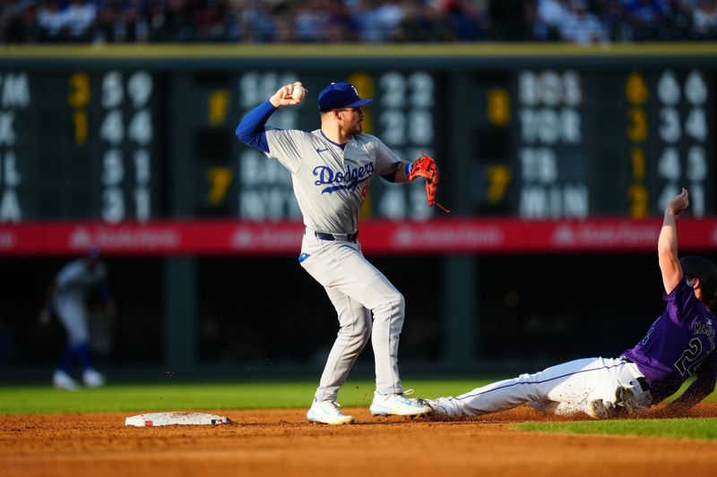 Jun 19, 2024; Denver, Colorado, USA; Los Angeles Dodgers second base Gavin Lux (9) turns a double play over Colorado Rockies third base Ryan McMahon (24) in the third inning at Coors Field. Mandatory Credit: Ron Chenoy-USA TODAY Sports