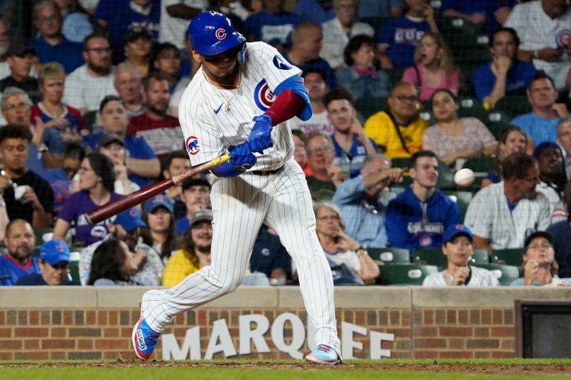 Sep 16, 2024; Chicago, Illinois, USA; Chicago Cubs third base Isaac Paredes (17) hits a one run single against the Oakland Athletics during the fourth inning  at Wrigley Field. Mandatory Credit: David Banks-Imagn Images