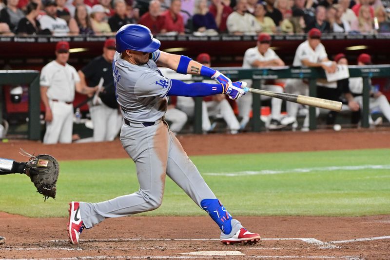 May 1, 2024; Phoenix, Arizona, USA;  Los Angeles Dodgers shortstop Miguel Rojas (11) hits a single in the third inning against the Arizona Diamondbacks at Chase Field. Mandatory Credit: Matt Kartozian-USA TODAY Sports